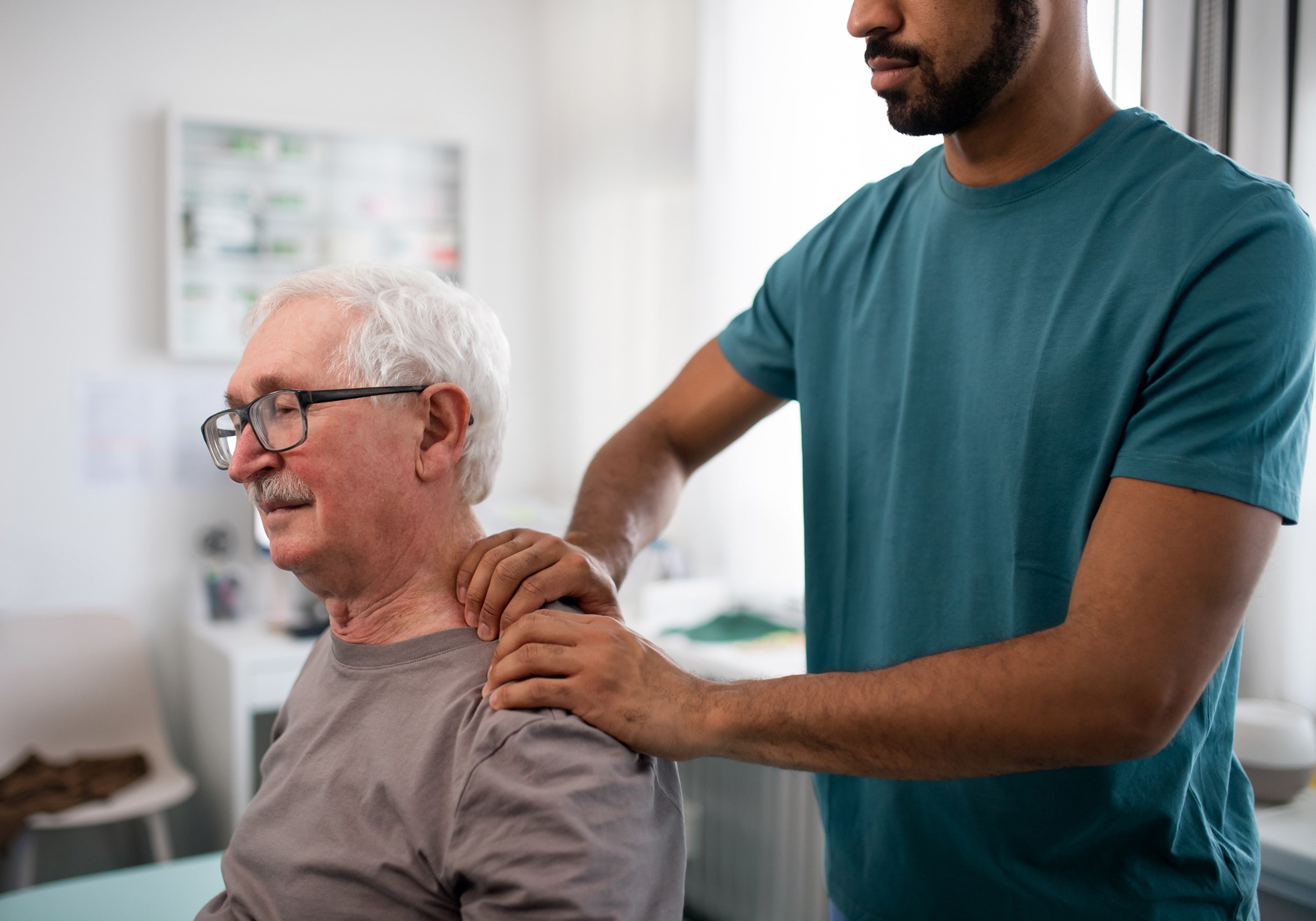 a person in a clinical space having their muscles checked in their neck