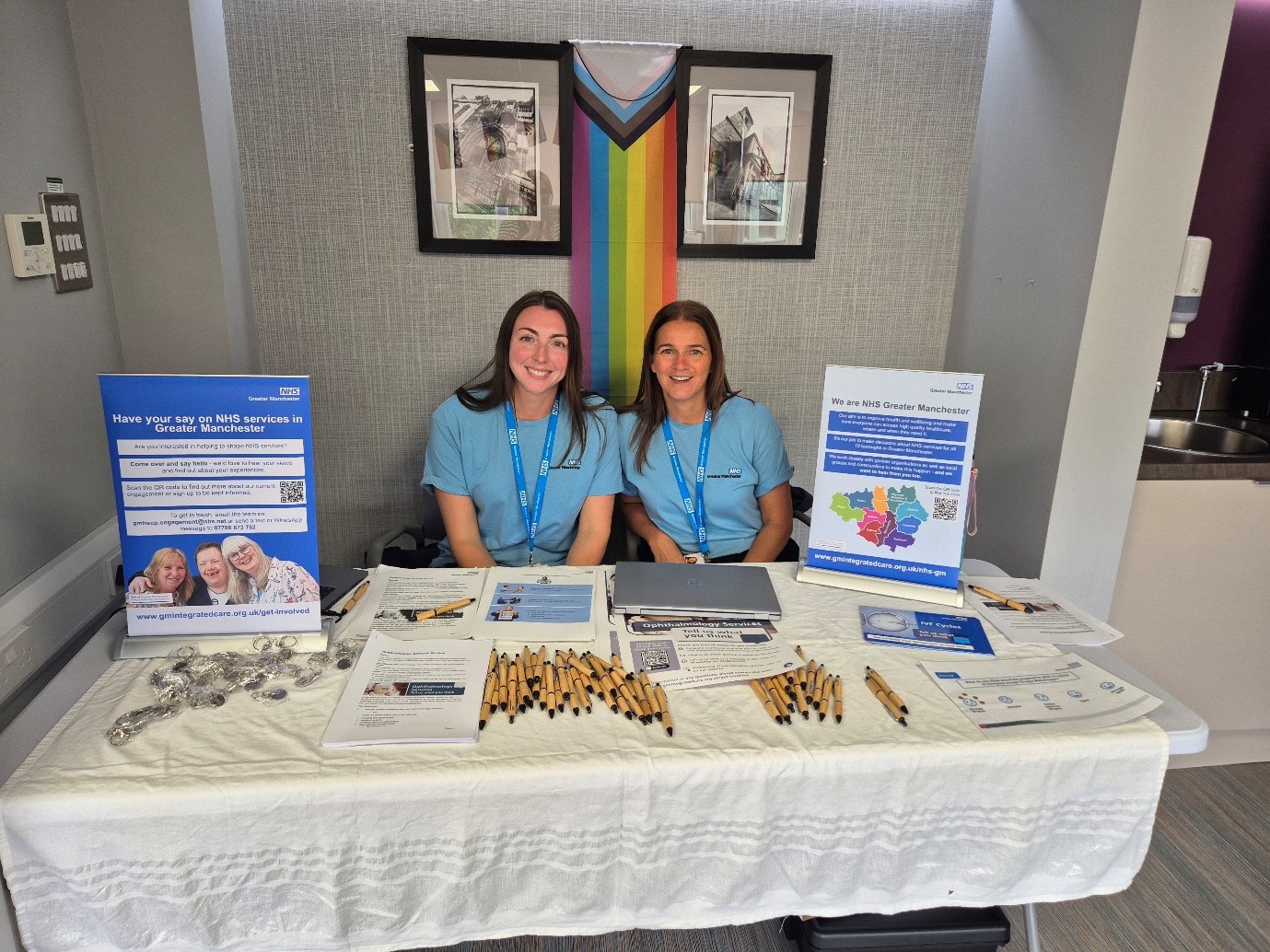 Engagement staff members sat behind a table with promotional materials for the IVF Cycles consultation.