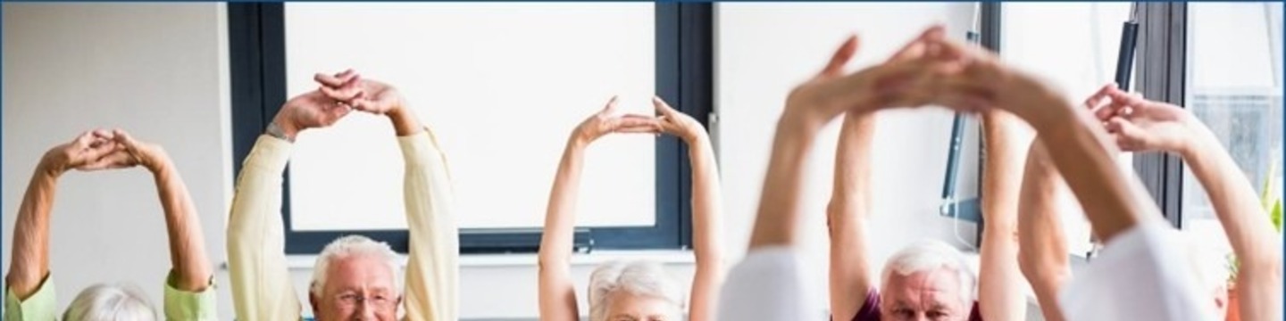 A group of people with arms stretched above their heads in exercise.